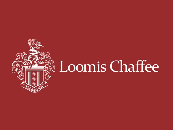 White Loomis Chaffee school crest and name on a maroon background. The ornate crest features a shield with symbols, a banner underneath, and a bird perched on top.